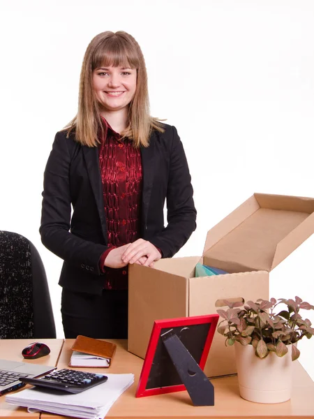 Meisje permanent achter een bureau met een grote doos — Stockfoto