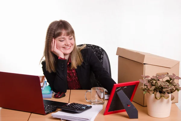 Smiling office employee looks at the picture frame — Stock Photo, Image