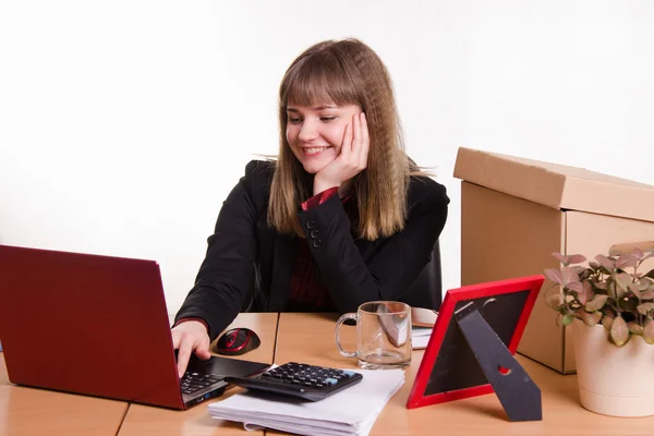 Office employee sitting at computer with a smile — Stock Photo, Image