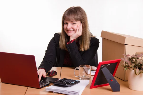 Lachende meisje zit in kantoor op computer — Stockfoto