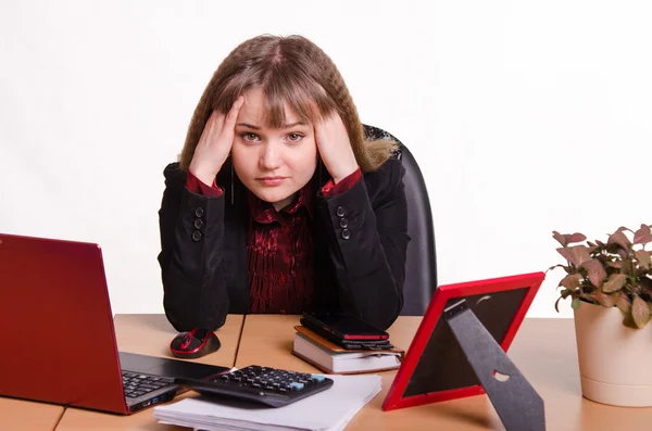 La chica detrás del escritorio de la oficina sosteniendo la cabeza con las manos — Foto de Stock