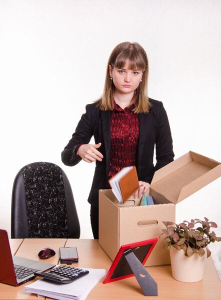 Уволенная девушка в офисе бросает свои вещи коробку

