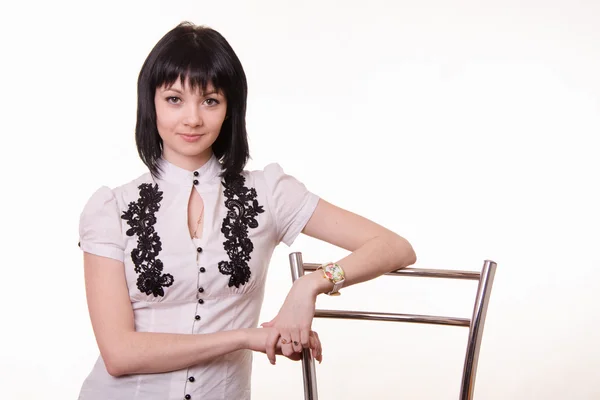 Half-length portrait of beautiful girl in a white blouse with back chair — Stock Photo, Image