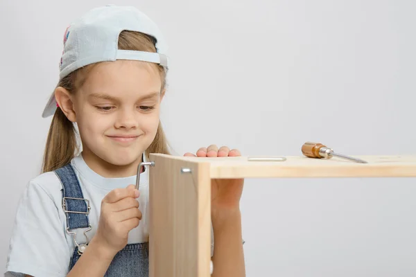 Meisje kleding verzamelaar meubels proberen om schroef — Stockfoto