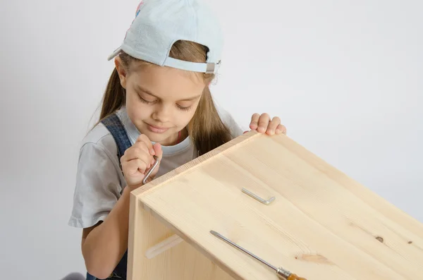 Little girl in the image of garbage furniture screw spins — Stock Photo, Image