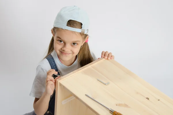 Little girl in image collector of furniture turn screw — Stock Photo, Image