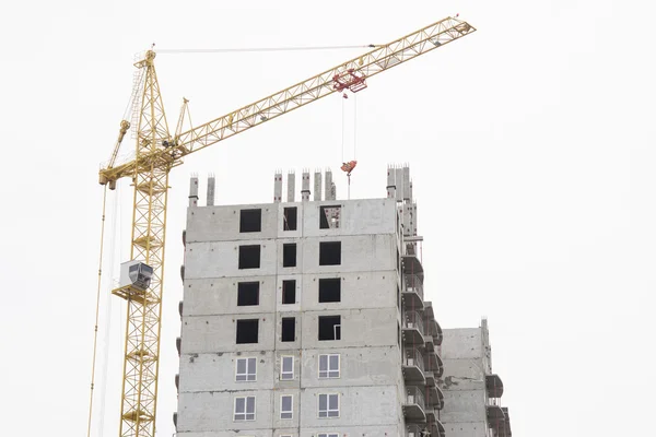 Unfinished house with a crane on construction site — Stock Photo, Image