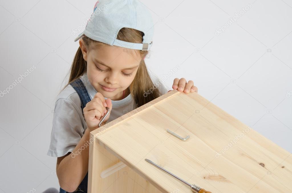 Little girl in the image of garbage furniture screw spins