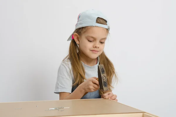 Girl scores carnations hammer, collecting cabinet — Stock Photo, Image