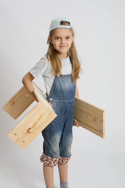 Porträt eines sechsjährigen Mädchens mit Brettern in den Händen — Stockfoto