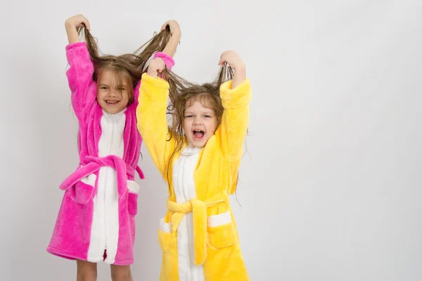 Две девушки в халатах подняли свои мокрые волосы — стоковое фото