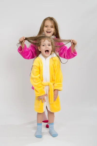 Chica sosteniendo su hermanas mojado cabello — Foto de Stock