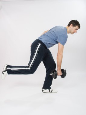 tek ayak üstünde duran dumbbells ile bir yamaç atlet gerçekleştirir