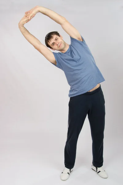 Jonge man trekt terug spieren — Stockfoto