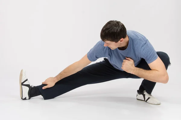 Atleet crouching trekken spieren van het rechterbeen — Stockfoto