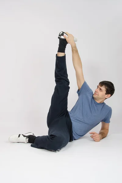 Idrottsman sträcker sig musklerna i benen genom att höja — Stockfoto