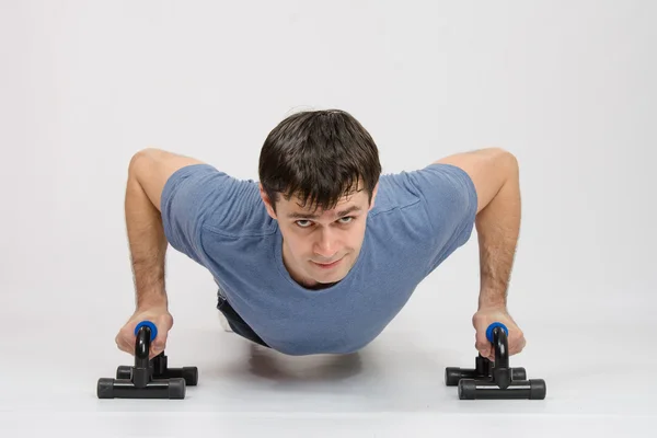 The athlete performs a bench on supports — Stock Photo, Image