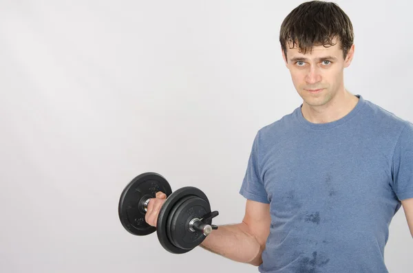 Athlete pumps muscle of the right hand using dumbbells — Stock Photo, Image