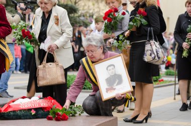 yaşlı kadın ile bir fotoğraf Savaş Anıtı çiçek bırakır