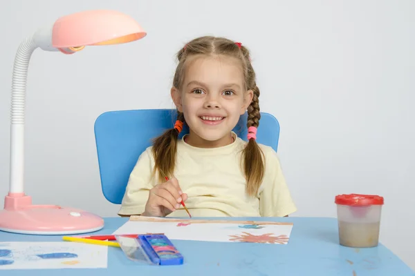Menina de seis anos sorrindo feliz, desenhando a mesa — Fotografia de Stock