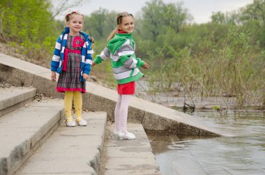 Suya yakın adımlar üzerinde duran iki kız