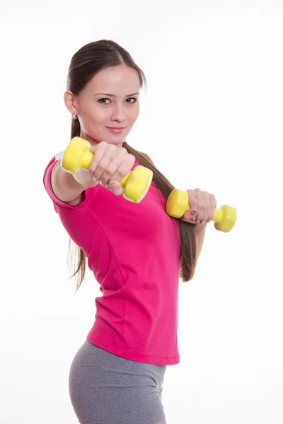 Beautiful athlete holding a dumbbell at arm's length — Stock Photo, Image