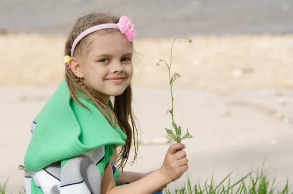 Meisje met sprietje gras in handen — Stockfoto