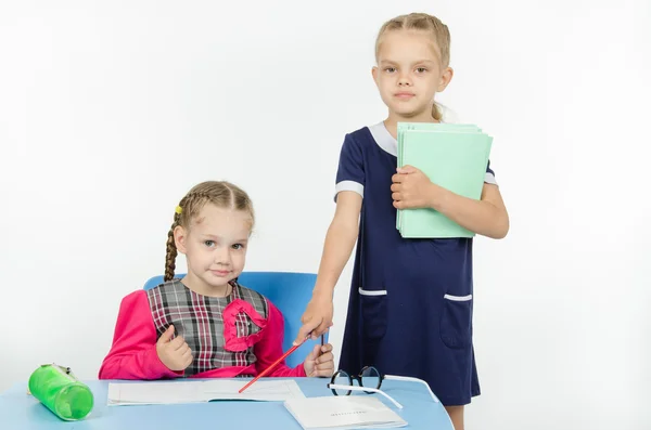 Girl teacher points at student notebook — Stock Photo, Image