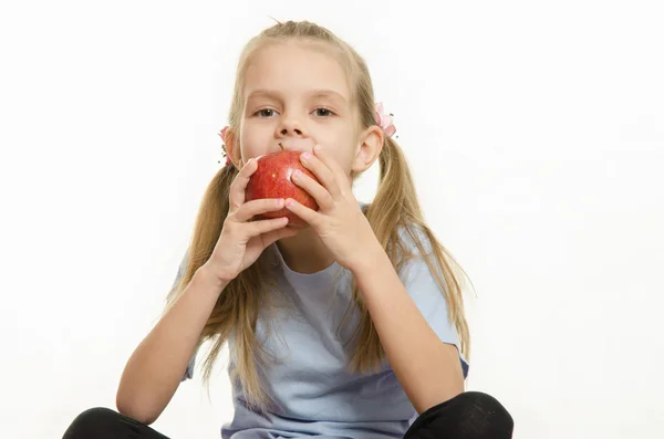 六岁的女孩坐，吃一个苹果 — 图库照片