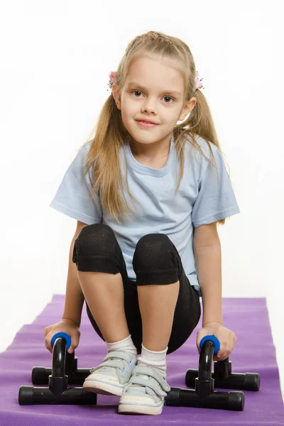 Six year old girl hanging on the palm pushups — Stock Photo, Image