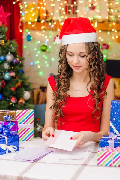 Ella pone una postal con saludos navideños en un sobre — Foto de Stock