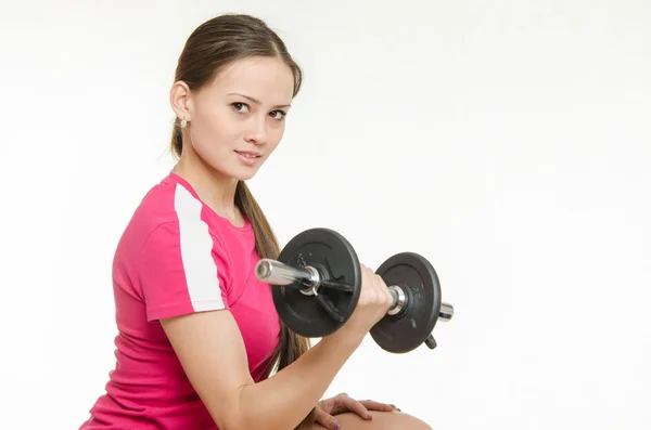 Athlete swings dumbbells muscles of the right hand — Stock Photo, Image