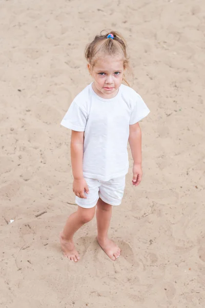 Расстроенная девушка, стоящая на песке — стоковое фото