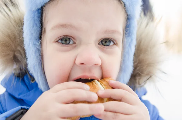 Menina comendo um rolo — Fotografia de Stock