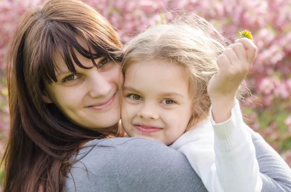 Porträtt av mor och dotter på våren bakgrund — Stockfoto