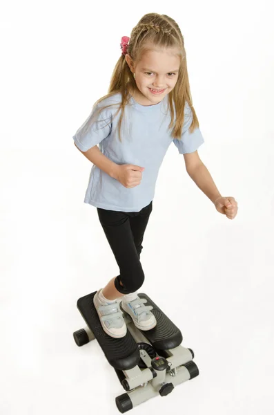 Six year old girl is engaged on a step simulator — Stock Photo, Image