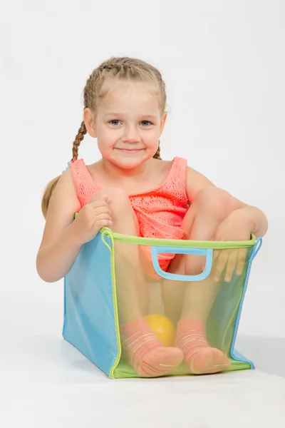 Cheerful girl in a box for toys — Stock Photo, Image