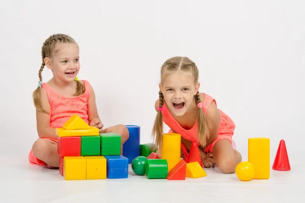 Twee meisjes lachen ongecontroleerd spelen dobbelstenen — Stockfoto