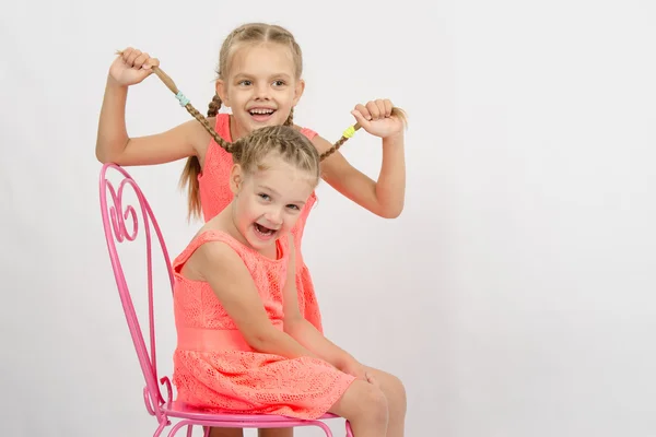 Girl having fun with pigtails sister — Stock Photo, Image