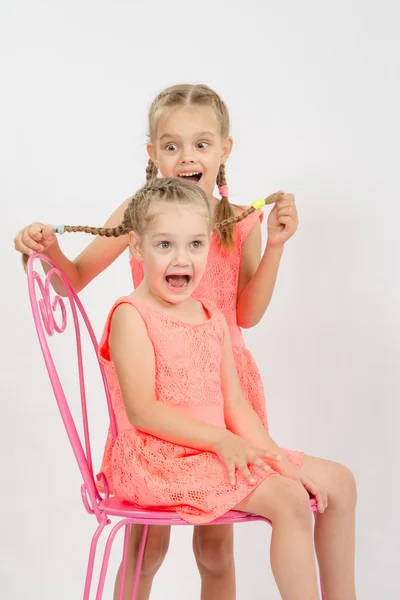 Girl fun grabbed the other girl's pigtails — Stock Photo, Image