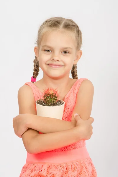 Glückliches kleines Mädchen umarmt Topf mit Kakteen — Stockfoto