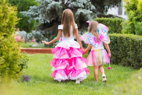 Duas meninas, princesa e fada passeando pelo jardim — Fotografia de Stock