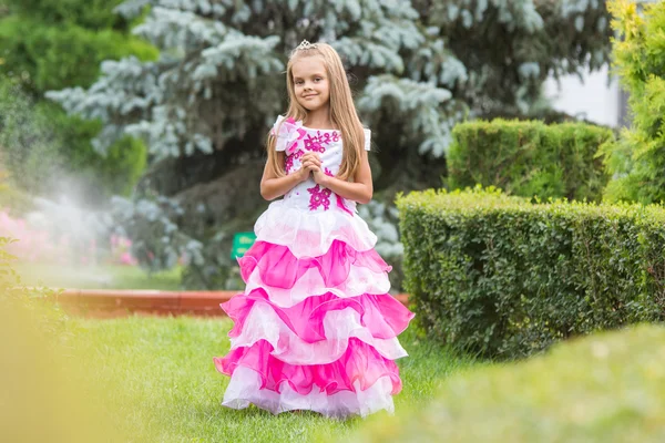 Girl princess stands on the lawn in the green garden — Stock Photo, Image