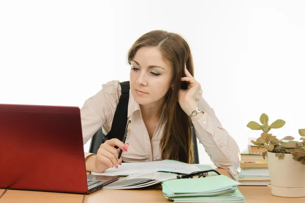 The teacher looks intently at a laptop — Stock Photo, Image