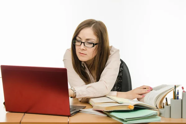 Teacher enthusiasm is looking for something in a notebook and books — Stock Photo, Image