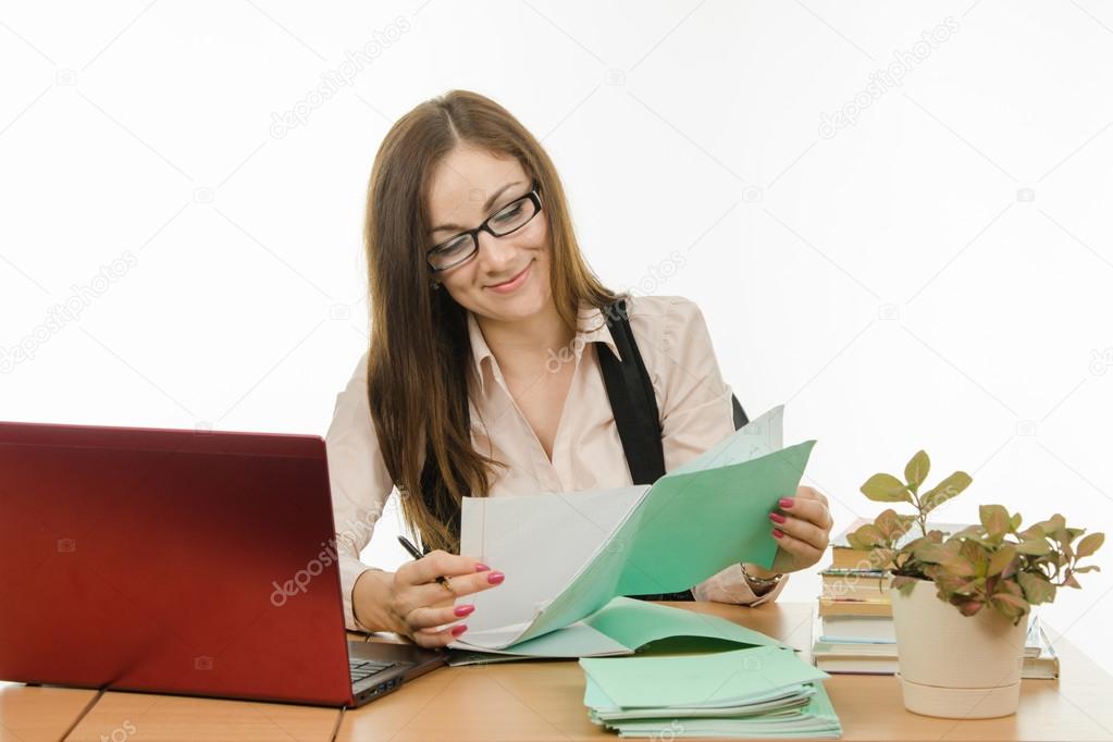 The teacher checks the student notebook