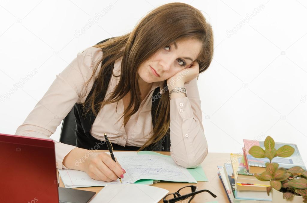 Tired teacher checks students notebooks