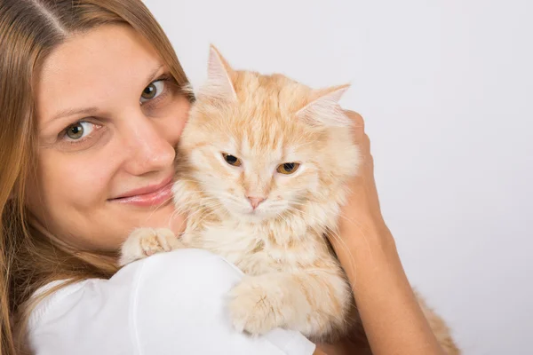 Girl hugging a disgruntled cat Stock Image