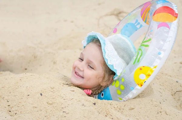 Девушка была похоронена в песке на пляже и положила его под голову — стоковое фото
