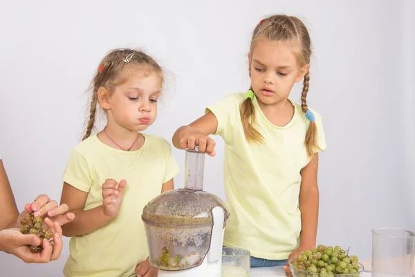 Tjejen åt en bit av päron är en annan tjej tränger ut juice — Stockfoto